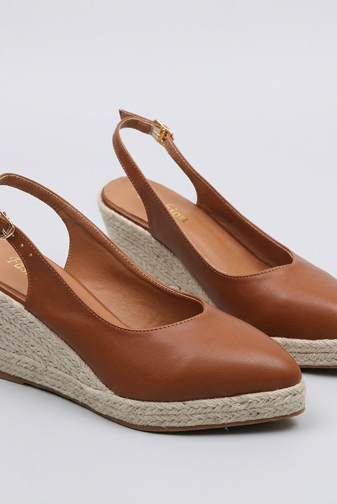 Brown wedge sandals with espadrille sole on a white surface