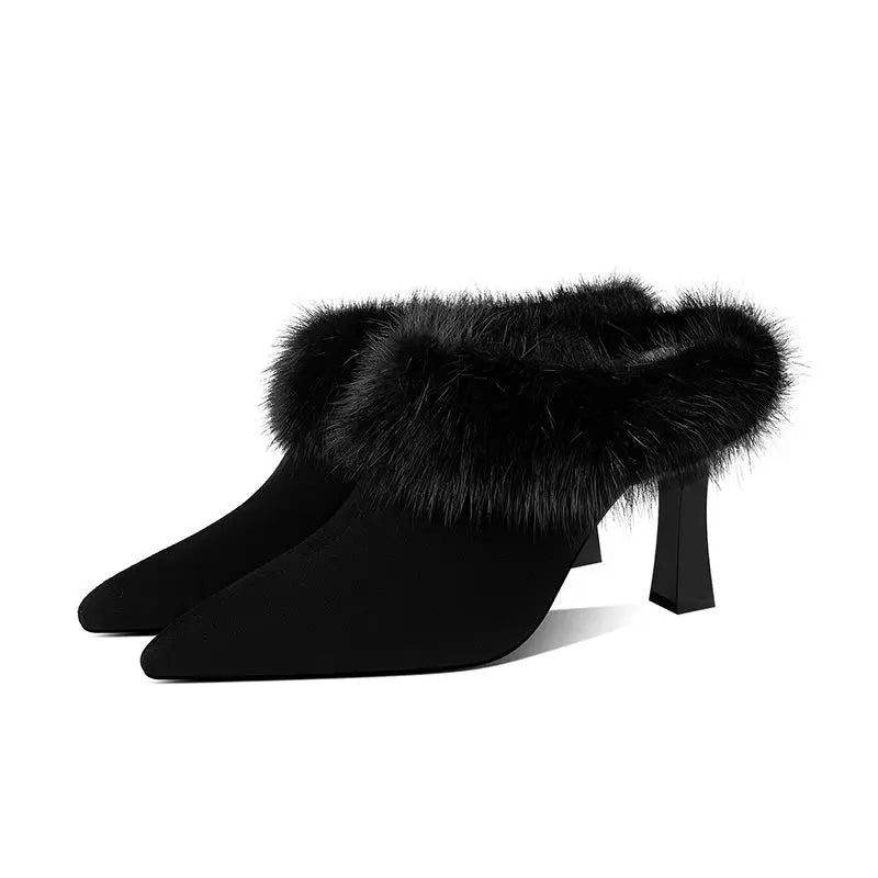 Black high-heeled shoes with fur trim on a white background